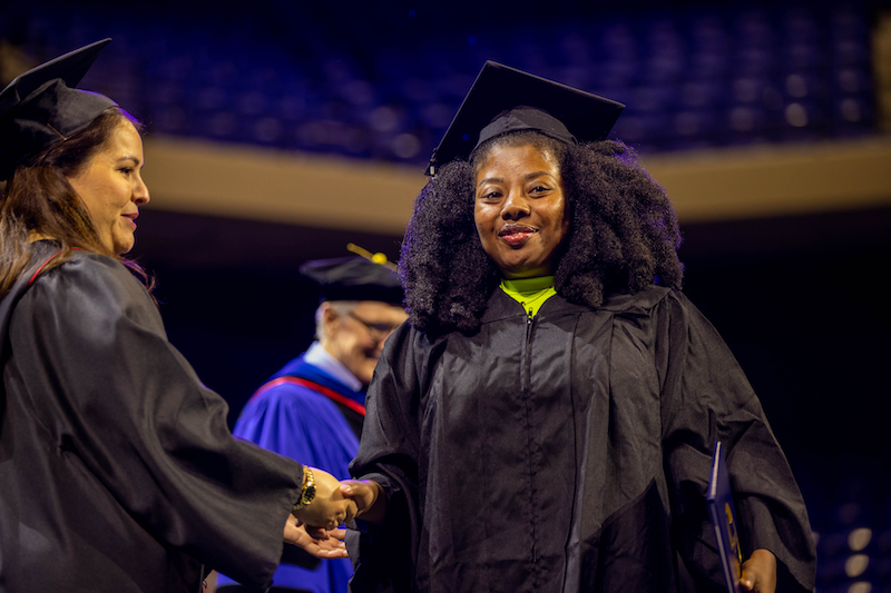 LSC-UP graduate Montoya Thomas walking across stage at commencement