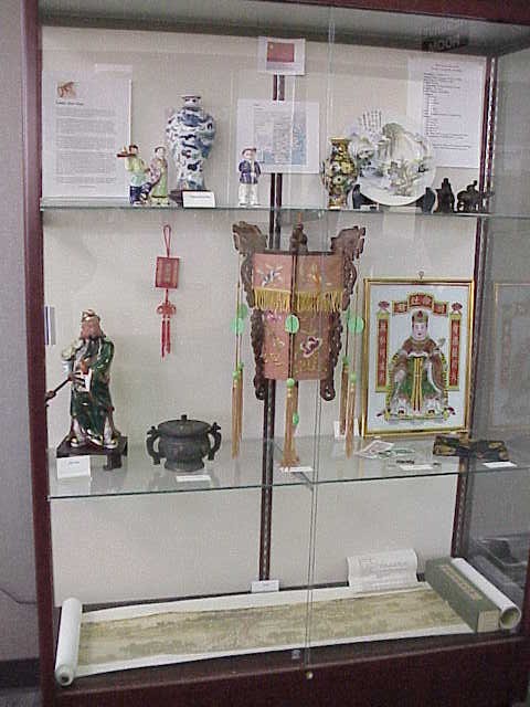The display featured a long handpainted scroll, partially revealed on the cabinet base, porcelain, and a traditional lantern.