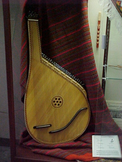 Close up of the bandura resting on a weaving from Ukraine, folk flute hanging above 