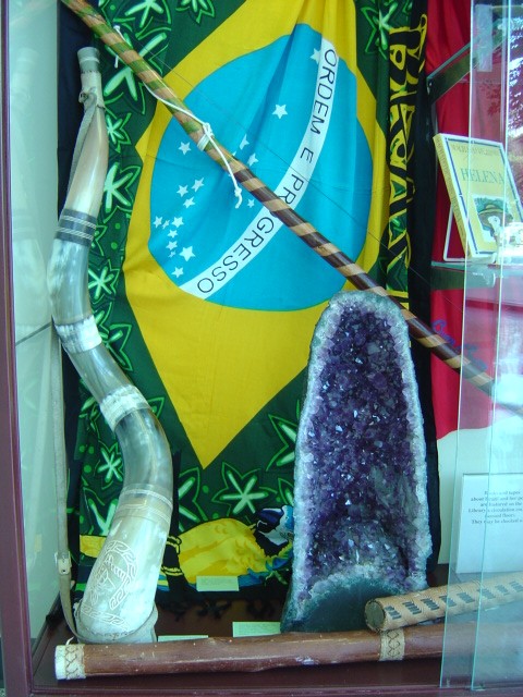 the flag of Brazil, a carved horn, the berimbau crossing behind the amethyst, and rain sticks