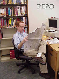 Brian Weis staying current with the news by reading a newspaper.
