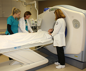 Students prepare a patient for a CT scan