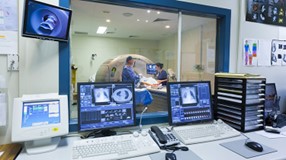 two people performing a CT scan on a third person