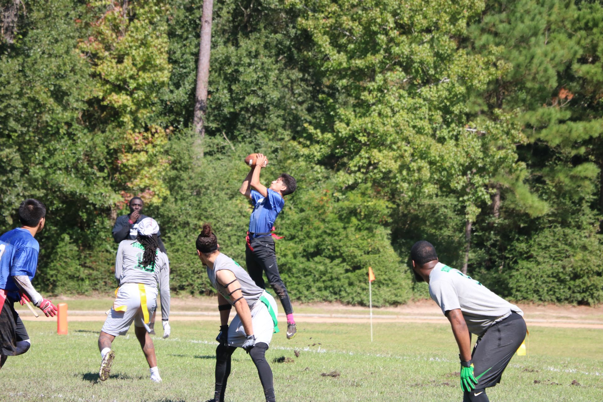 Photo of students from two different teams playing flag football