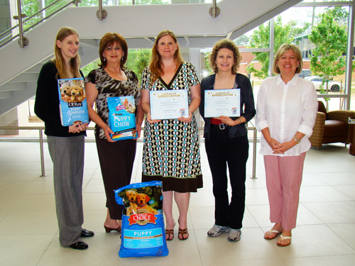 Representatives from the behavioral and social sciences division at Lone Star College-Montgomery showcase a small portion of the more than 1,100 pounds of puppy chow donated by students, staff, and faculty to The Friendship Centers Pet Food Project. Pictured left to right are: Ally Lamb, department assistant; Cecile Allemand, coordinator; Kara Chapman, division coordinator; Julie Alber, professor of speech; and Kris Demlich, coordinator of The Pet Food Project for The Friendship Center.