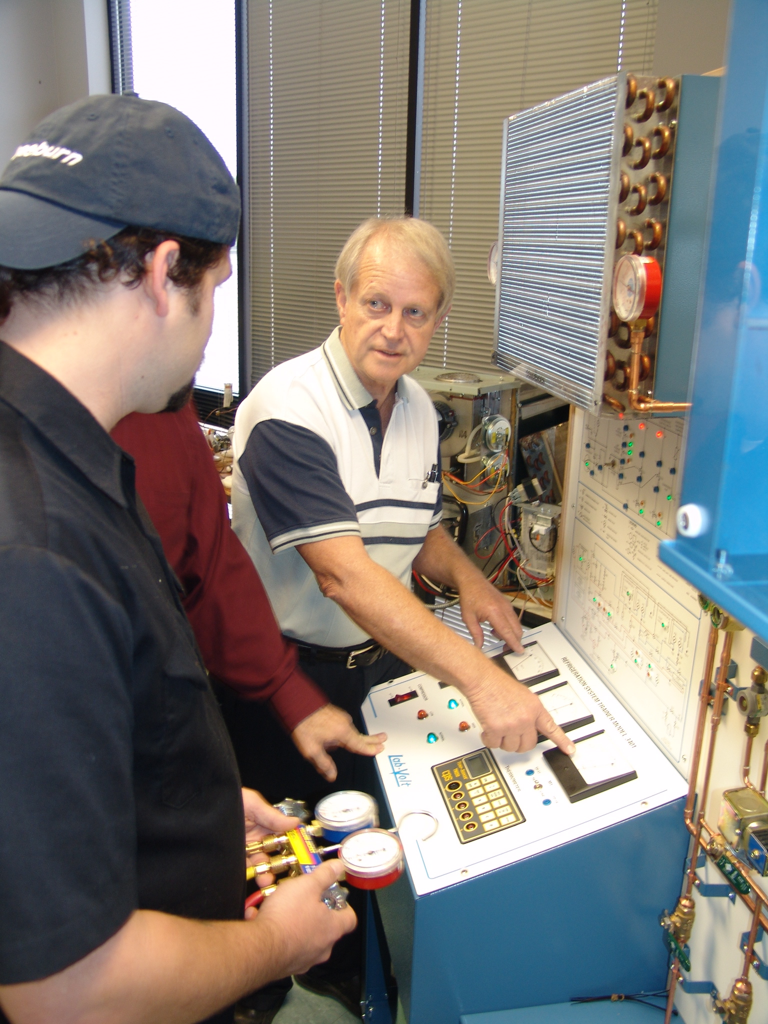 Instructor Robert Watts shows his students some of the technical aspects of testing a cooling system.