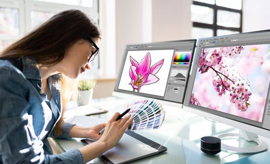 Graphic designer picking out colors in front of two monitors