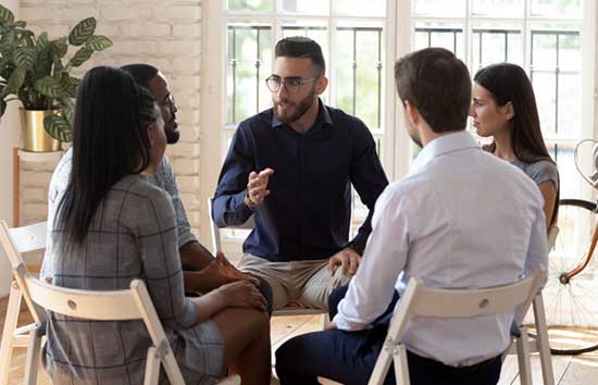 5 people sitting in a circle in a meeting