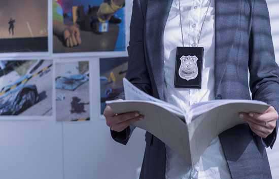 Person wearing a police badge looking at their notes