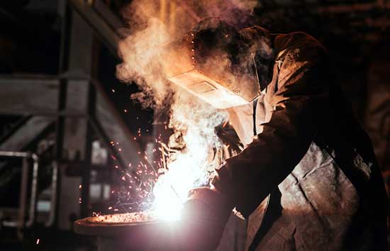 A welder working with a mask on