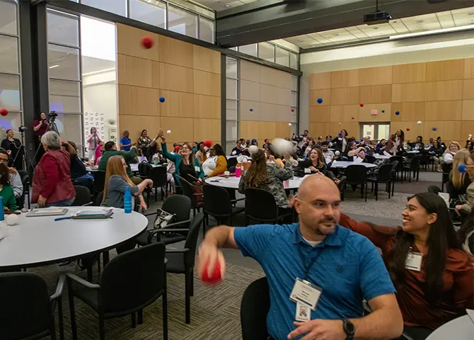 Employees throwing balls in a big hall