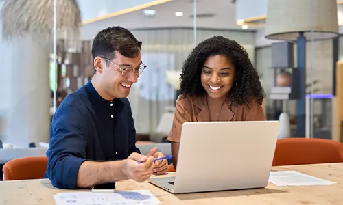 happy employees looking at laptop
