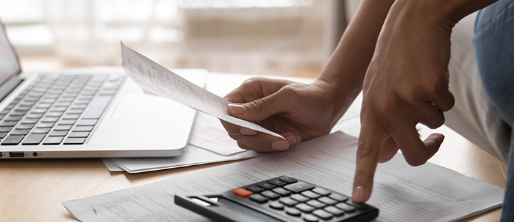 Hands holding a receipt and using a calculator 