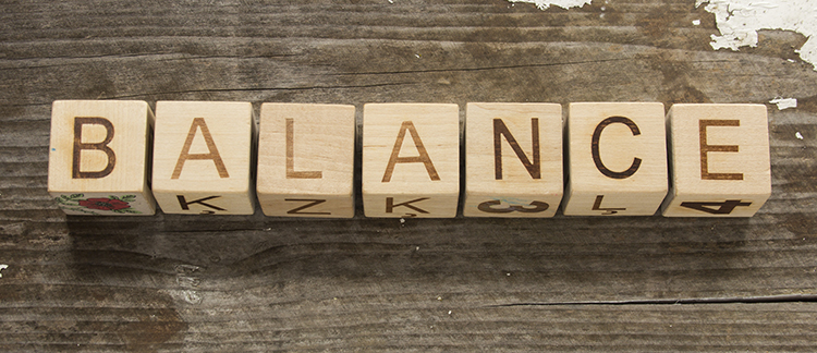 A row of wooden cubes that spell out BALANCE