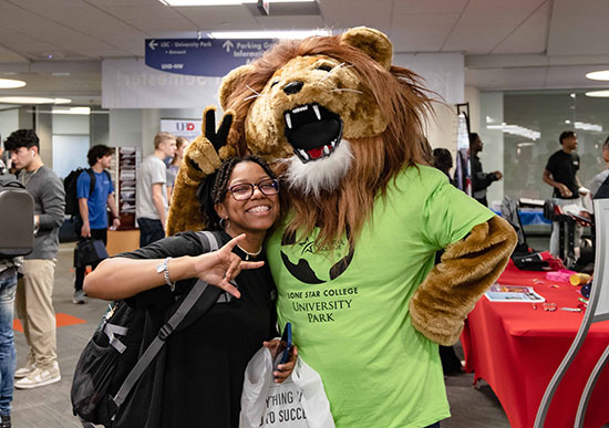 Leo Lion Mascot with Student Giving Peace and Love Hand Signs