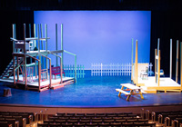 Looking down from the top row of the PAC, a blue sky is revealed behind the skeleton of a two-story set.