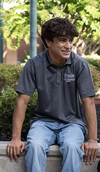 Ricard S - maverick student sitting on cement bench