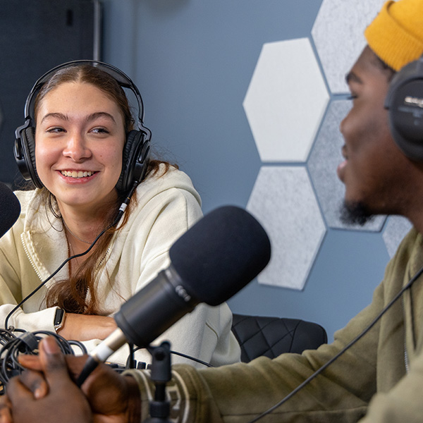 Photo of two students using multimedia equipment to record a video