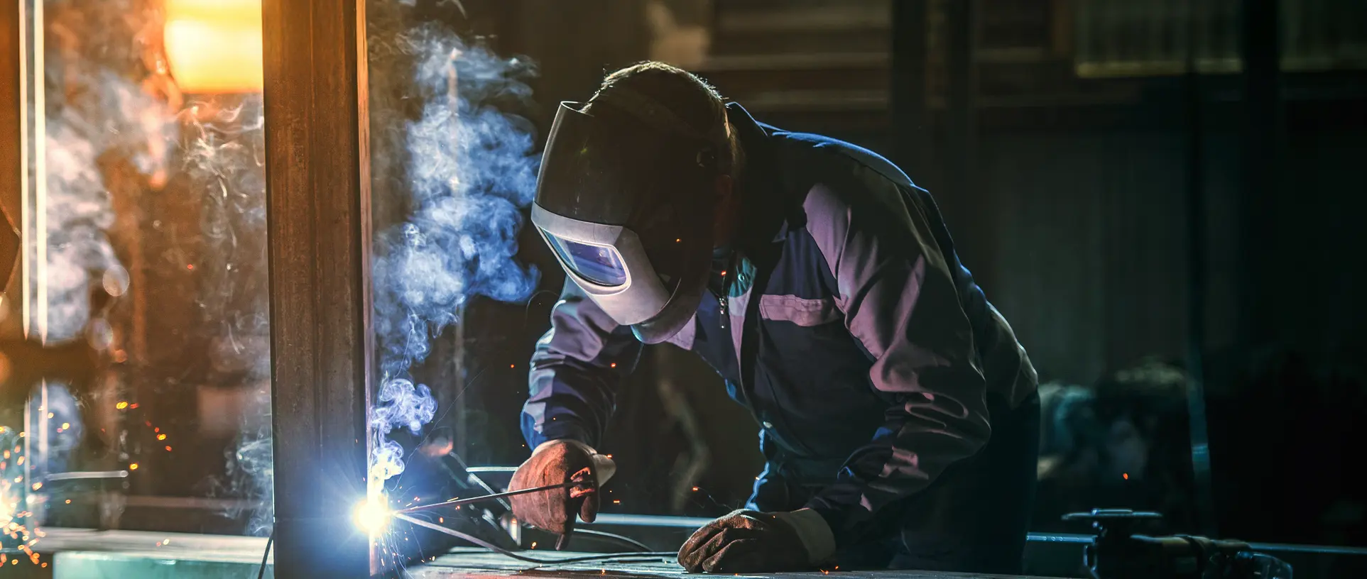 Welder welding with his face guard on