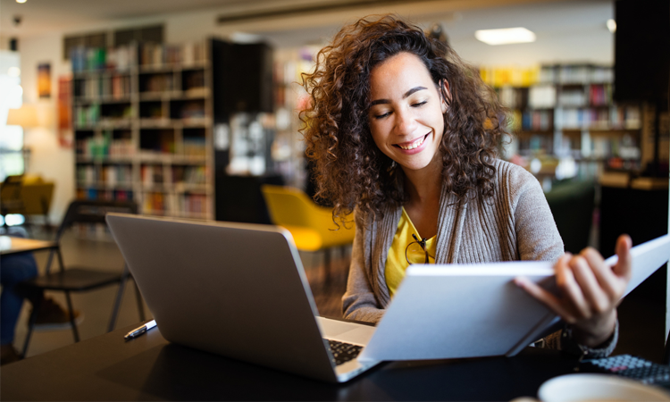 Girl with laptop and book