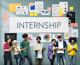 Image of student interns standing in front of a wall covered in work documents