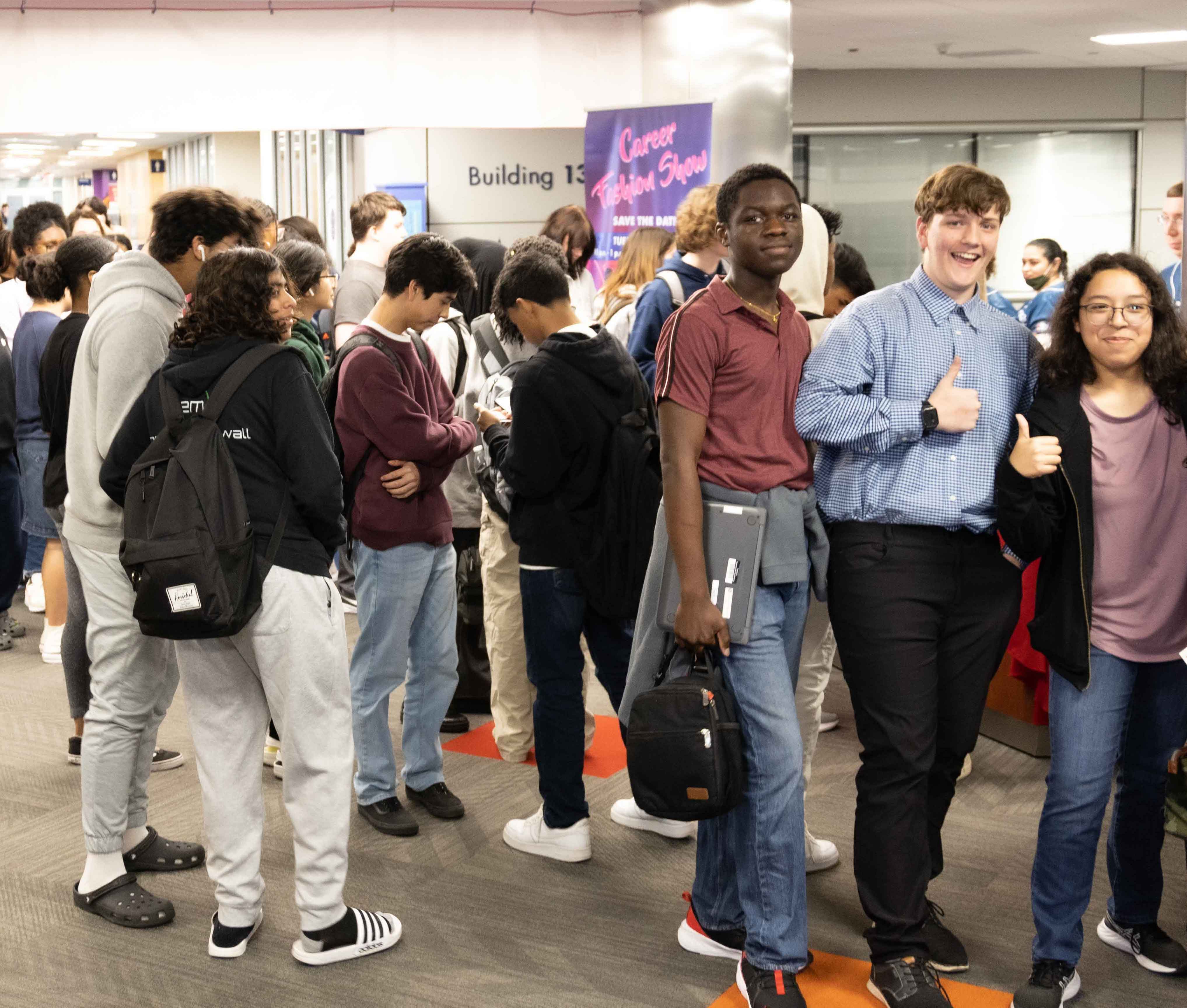 Students giving thumbs up at crowded registration event