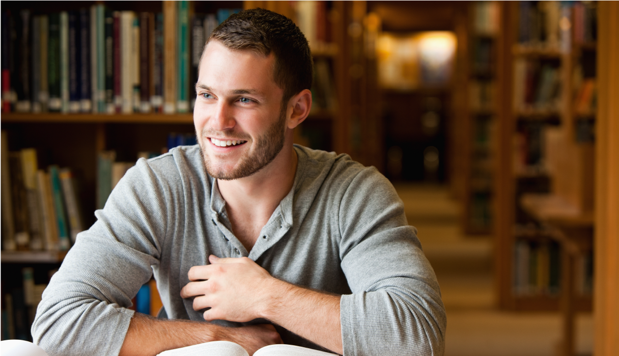 Male student sitting in library