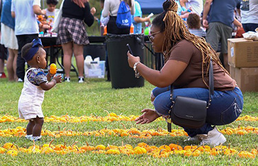 Toddler at Cy-Fest 2023 exploring the pumpkin patch