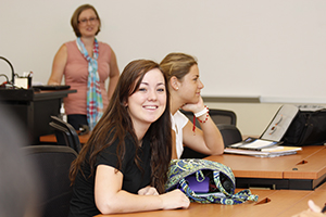 student with backpack on desk in a classroom