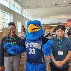 Photo of Cy standing with students