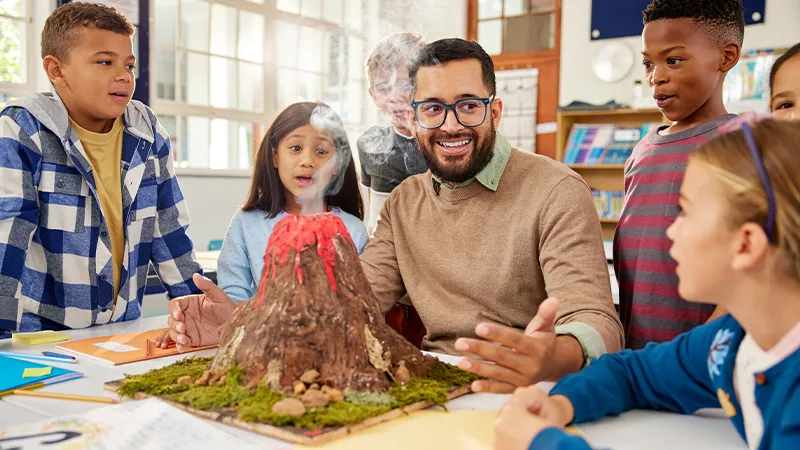 Teacher explaining volcano eruption to elementary class