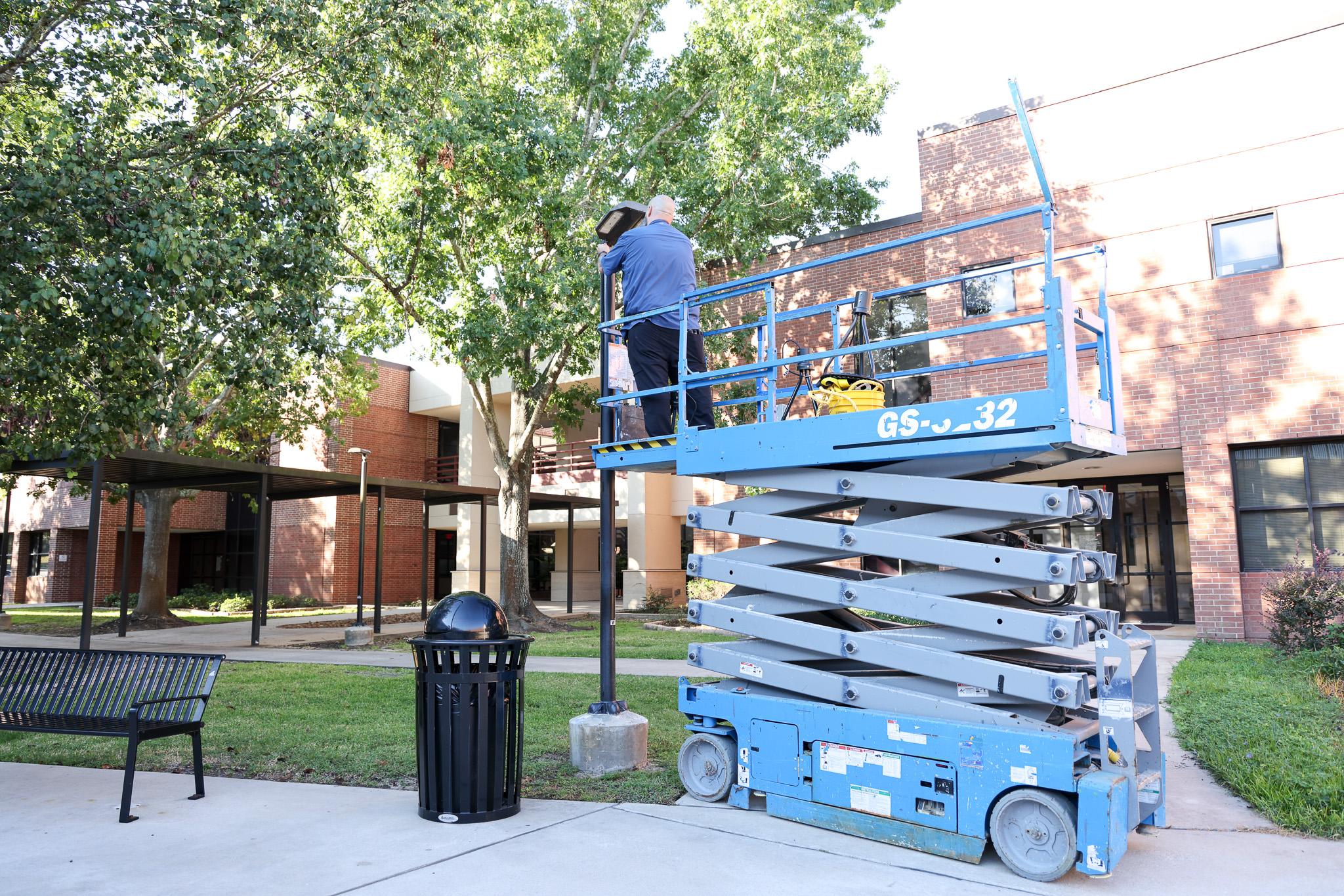 Maintenance fixing lightbulb outside 