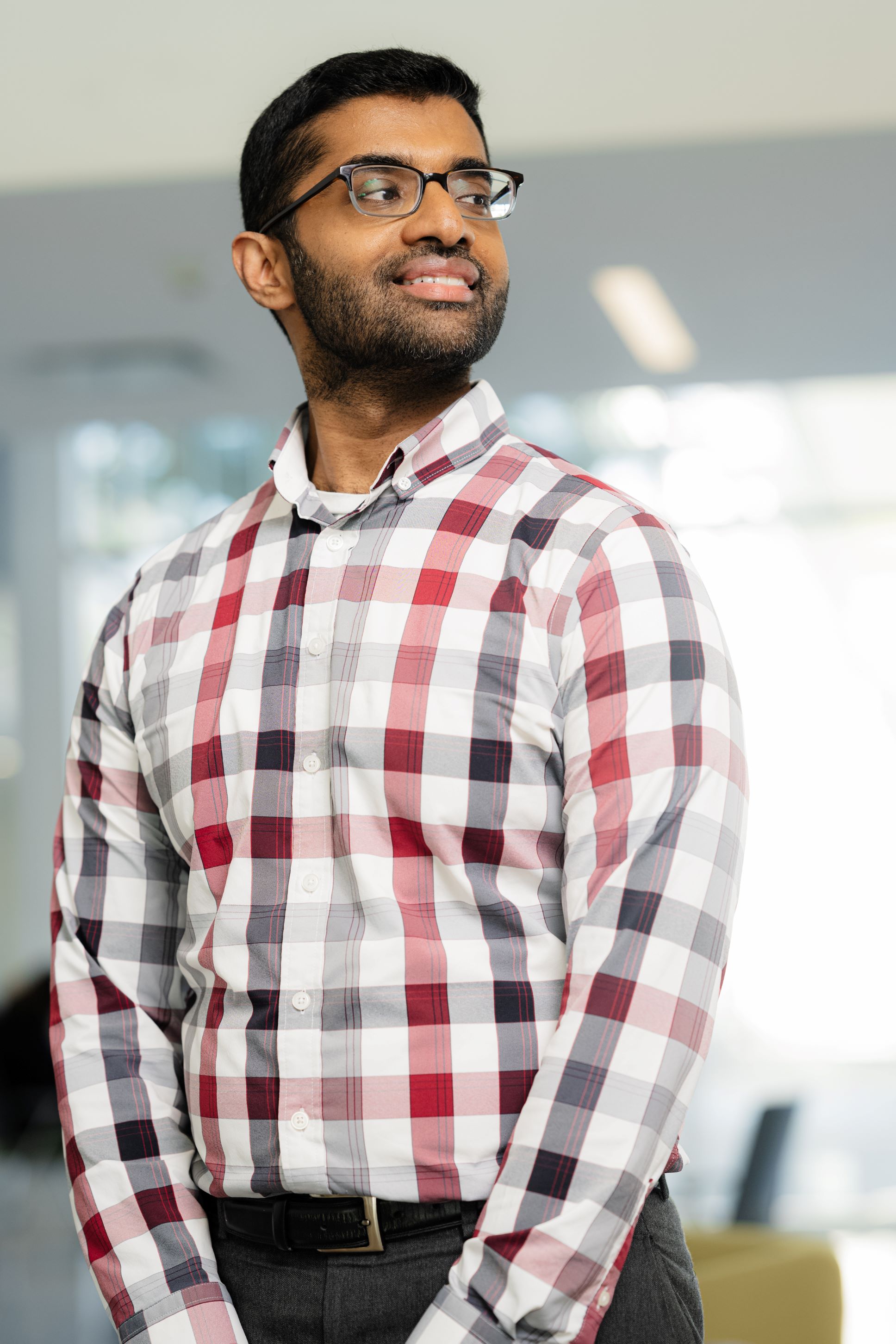 A picture of a Professor in the classroom wearing glasses. 