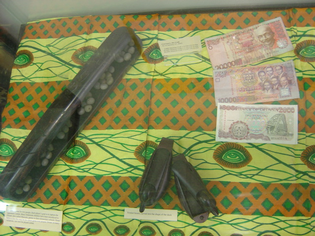 an ancient game, wooden boxes in the shape of ducks, and money from Ghana
