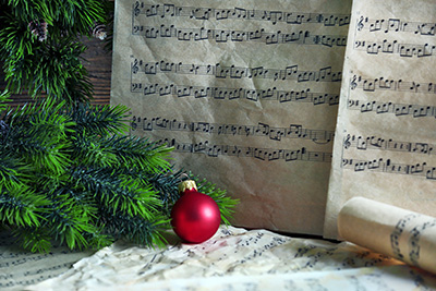 Holiday ornament and music manuscripts illustrating the "Sounds of Wonder" Choral Charity Concert