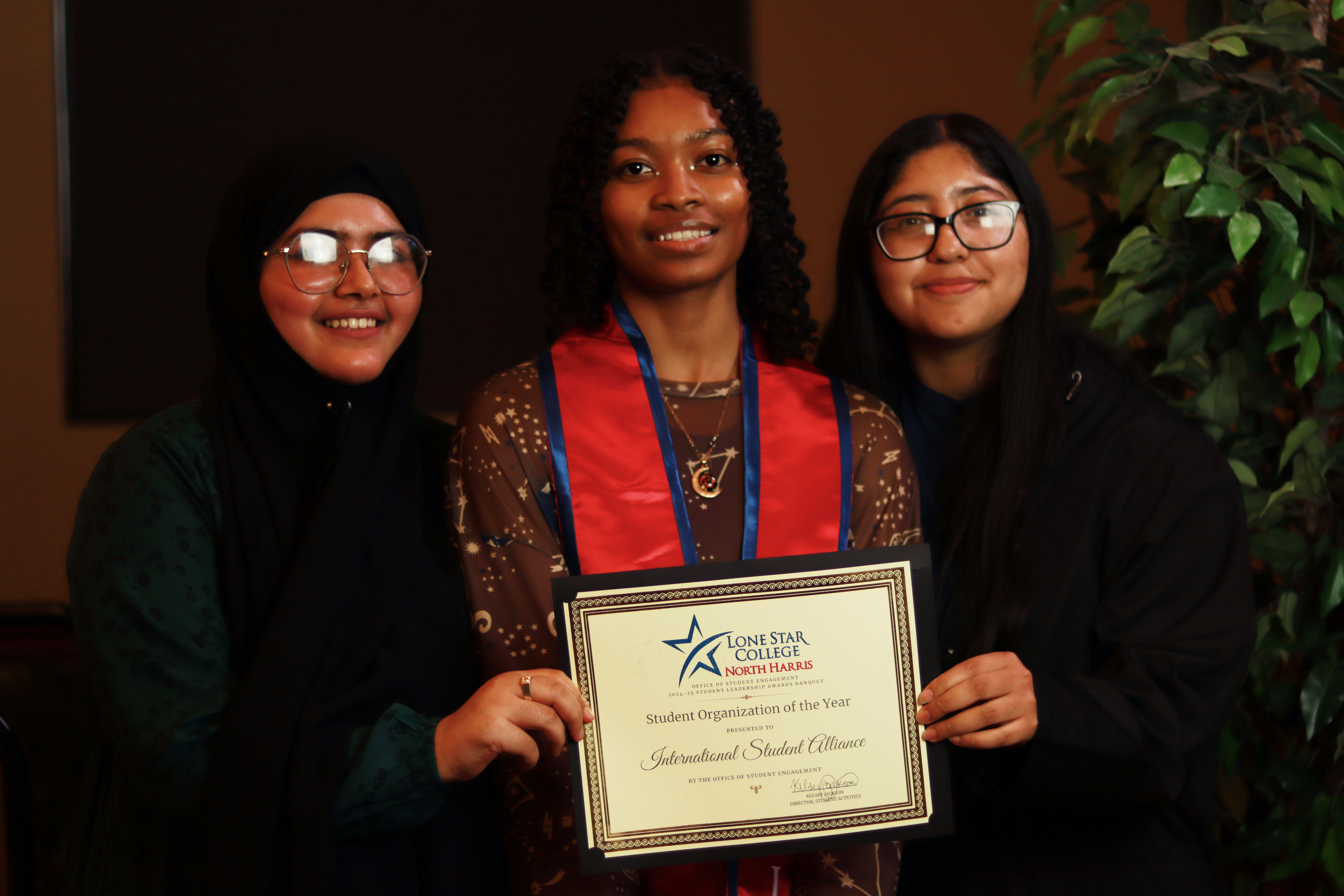 3 female students holding an award certificate