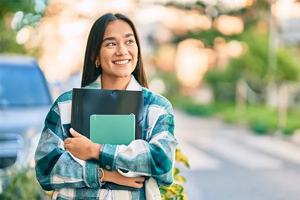Smiling student holding binder