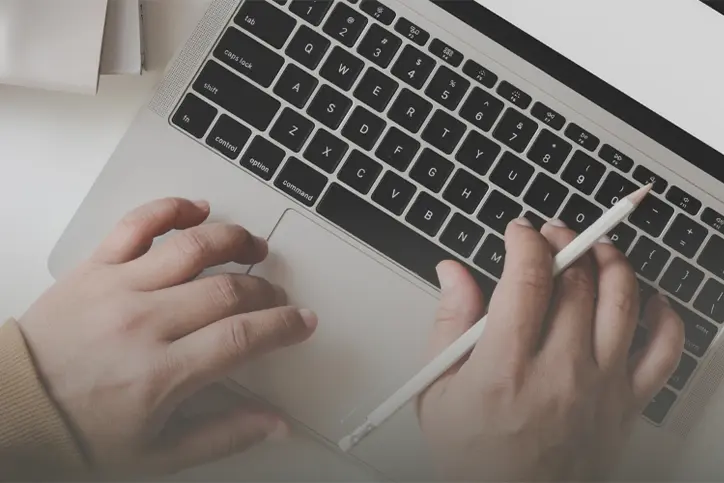 Hands typing on a laptop