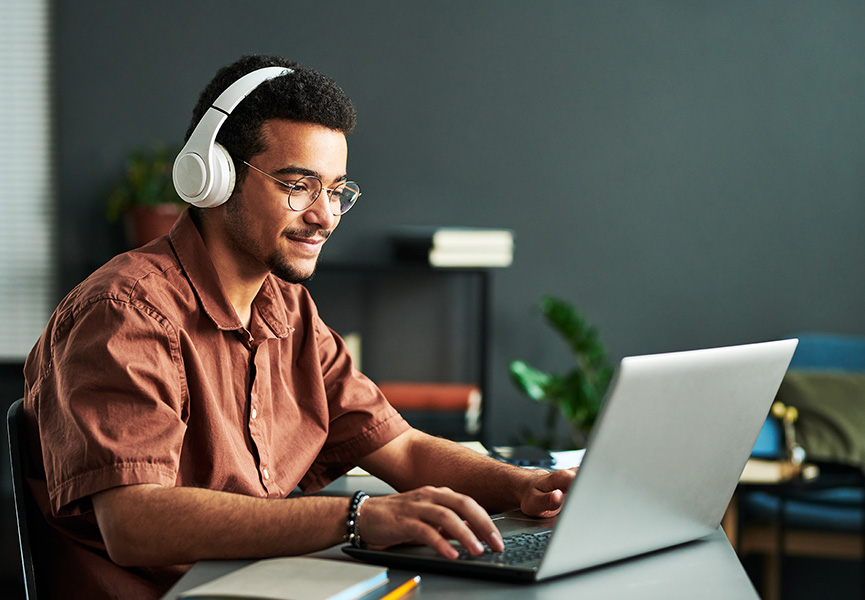 Photo of student taking a tutorial online using his laptop