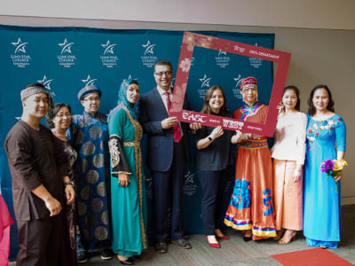 Several individuals in traditional international clothing celebrating East Meets West Festival Spring 2018