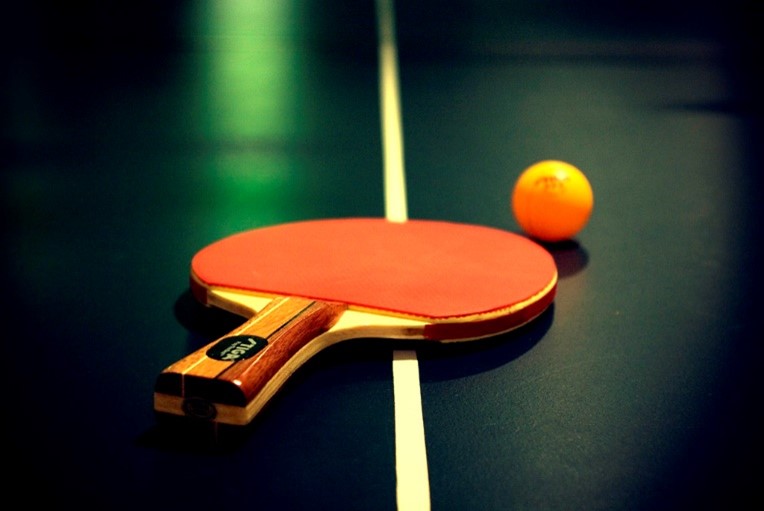 ping pong paddle and ball on table