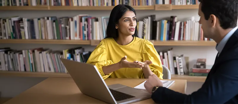 Woman talking to man in library