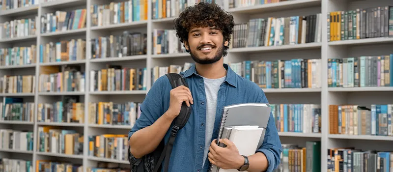 Student in front of library wall