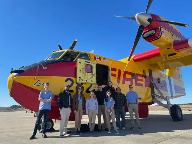 Students in front of a propeller type plane