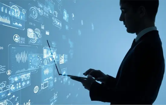 Man using a laptop in front of holograms of graphs