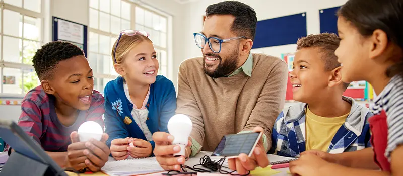 Smiling teacher showing students solar panels