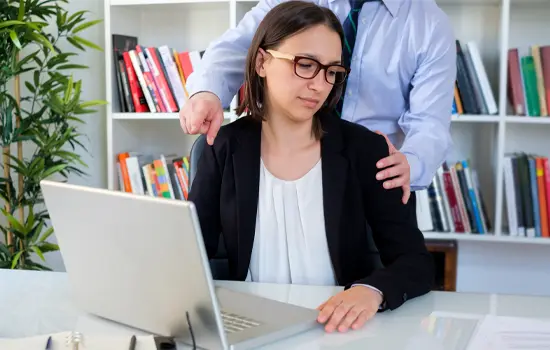Staff member uneasy as another staff member touches her shoulder 