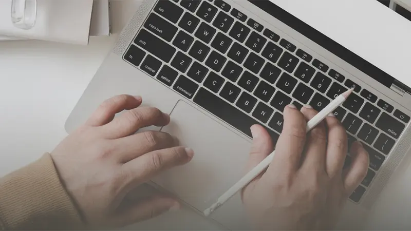 hands typing on a laptop