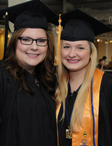 Two smiling graduates in regalia