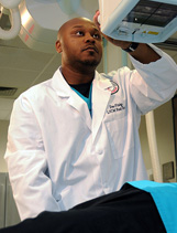 A student wearing a lab coat and working with medical equipment